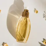 Elegancka butelka perfum, otoczona suszonymi kwiatami. Idealne perfumy odpowiedniki dla Ciebie.