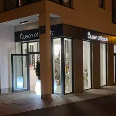 Elegancki salon "Queen of Beauty" nocą. Wnętrze rozświetlone, widać klientki. Czekam na pozytywne queen of beauty opinie!