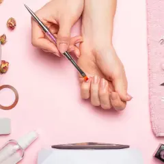 Narzędzia do manicure i dłonie przygotowujące się do zabiegu. Dowiedz się, jak zdjąć tipsy i uzyskać naturalny wygląd paznokci.
