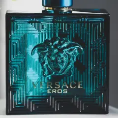 Elegancka butelka Versace Eros, symbol najlepszych męskich perfum. Intensywny, turkusowy kolor i złote detale przyciągają wzrok.
