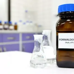 Butelka z etykietą "FORMALDEHYDE CH₂O, 37%" i kolby laboratoryjne. Formaldehyd co to?