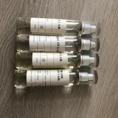 Cztery małe flakoniki perfum "MADE IN LAB." na drewnianym tle. Opinie o nich są pozytywne, doceniane za zapachy.