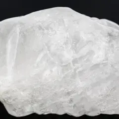 Surowy, biały ałun, minerał o szklistym połysku, z widocznymi wewnętrznymi pęknięciami.