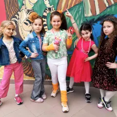 Pięć dziewczynek w kolorowych strojach, gotowych na imprezę w stylu disco.