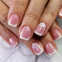 Eleganckie paznokcie konstrukcyjne w stylu francuskim z delikatnym białym zdobieniem przypominającym śnieżynki.