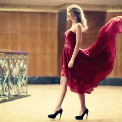Elegancka kobieta w bordowej sukience i czarnych szpilkach, idealne buty do bordowej sukienki.
