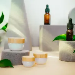 Kremy i serum w brązowych buteleczkach, otoczone zielonymi liśćmi. Wiele osób szuka o nich cerave opinie, by wybrać najlepszy kosmetyk.