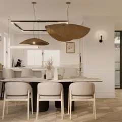 Elegancka jadalnia z marmurowym stołem i beżowymi krzesłami, oświetlona designerskimi lampami. To kwintesencja quiet luxury.
