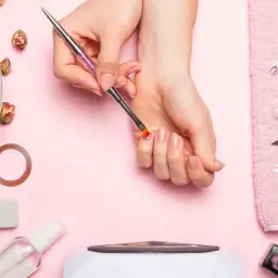 Narzędzia do manicure i dłonie przygotowujące się do zabiegu. Dowiedz się, jak zdjąć tipsy i uzyskać naturalny wygląd paznokci.