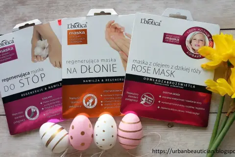 Zestaw masek do stóp, dłoni i twarzy L'biotica z olejkiem z dzikiej róży. Obok wielkanocne pisanki i żonkile.