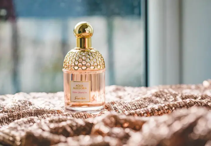 Elegancka butelka perfum Guerlain Aqua Allegoria Pera Granita na błyszczącym materiale. Czy Notino ma oryginalne perfumy? Ten flakon wygląda autentycznie.