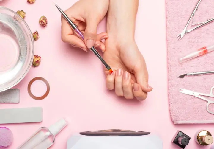 Narzędzia do manicure i dłonie przygotowujące się do zabiegu. Dowiedz się, jak zdjąć tipsy i uzyskać naturalny wygląd paznokci.