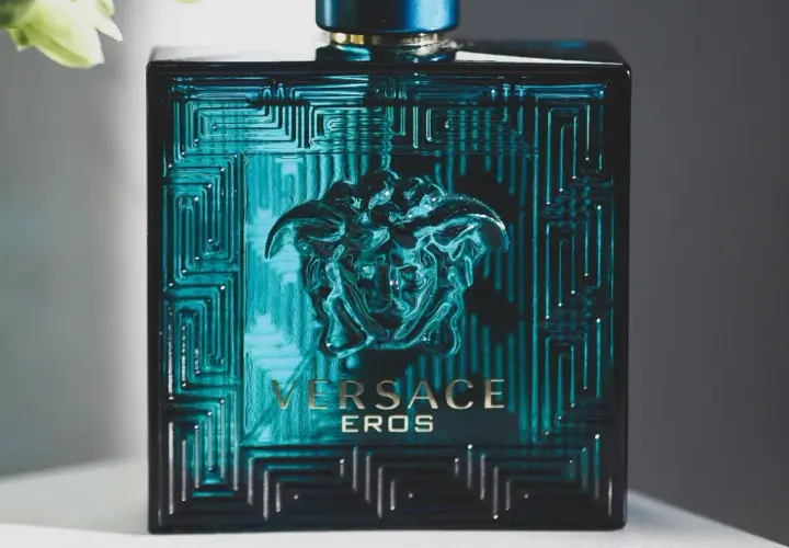 Elegancka butelka Versace Eros, symbol najlepszych męskich perfum. Intensywny, turkusowy kolor i złote detale przyciągają wzrok.