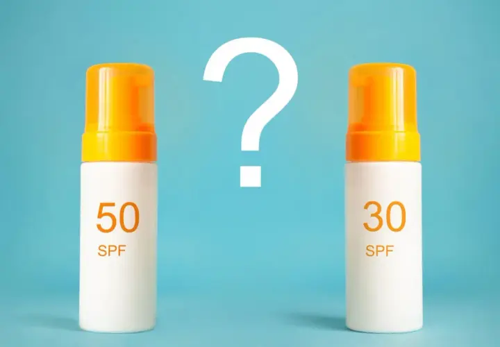 Jaki SPF do twarzy wybrać? Dwa kremy z filtrem SPF 50 i SPF 30 stoją obok siebie, a nad nimi wielki znak zapytania.