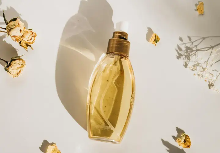 Elegancka butelka perfum, otoczona suszonymi kwiatami. Idealne perfumy odpowiedniki dla Ciebie.