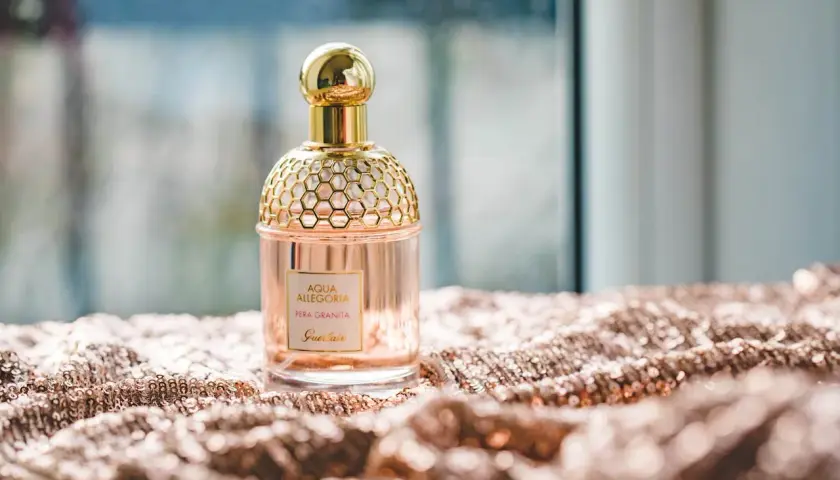 Elegancka butelka perfum Guerlain Aqua Allegoria Pera Granita na błyszczącym materiale. Czy Notino ma oryginalne perfumy? Ten flakon wygląda autentycznie.