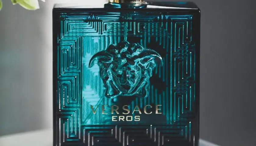 Elegancka butelka Versace Eros, symbol najlepszych męskich perfum. Intensywny, turkusowy kolor i złote detale przyciągają wzrok.