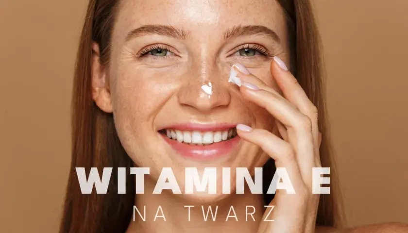 Uśmiechnięta kobieta z piegami aplikuje krem pod oczy. Witamina E na twarz dla promiennej cery.