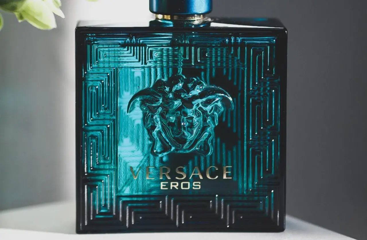 Elegancka butelka Versace Eros, symbol najlepszych męskich perfum. Intensywny, turkusowy kolor i złote detale przyciągają wzrok.