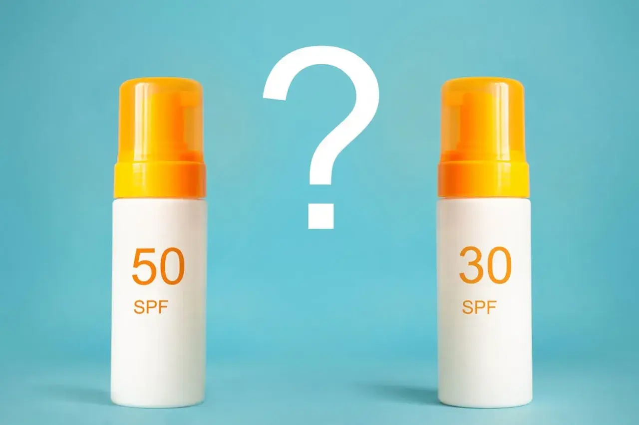Jaki SPF do twarzy wybrać? Dwa kremy z filtrem SPF 50 i SPF 30 stoją obok siebie, a nad nimi wielki znak zapytania.