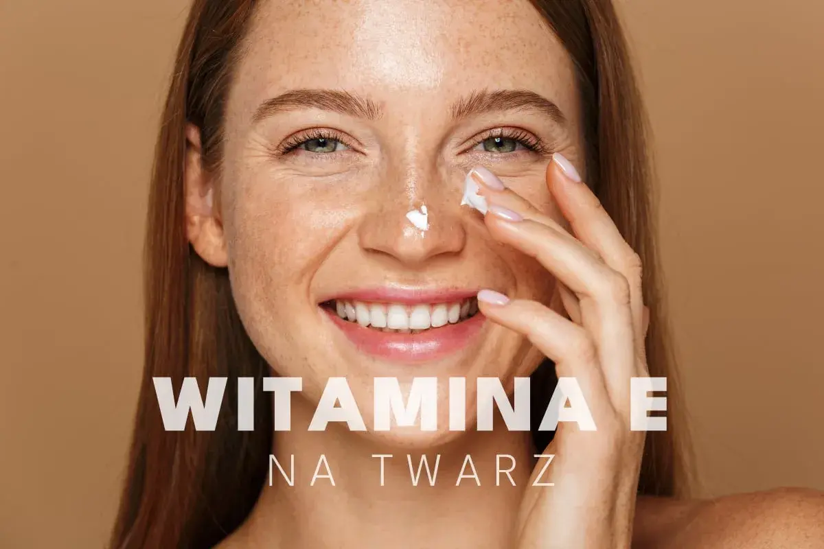 Uśmiechnięta kobieta z piegami aplikuje krem pod oczy. Witamina E na twarz dla promiennej cery.