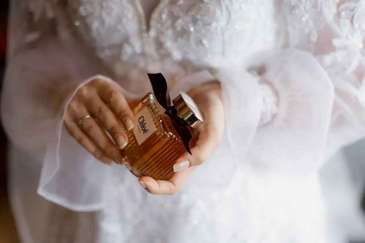 Dłonie trzymają buteleczkę perfum Chloé, idealną do ślubnego rankingu perfum damskich.