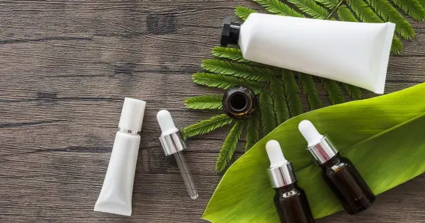 Buteleczki z serum i kremem na drewnianym tle, wśród liści. Dylemat: retinol czy retinal?